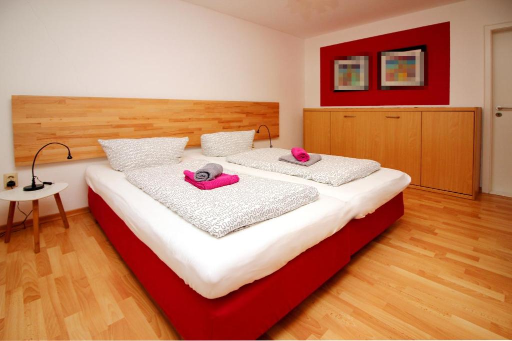 リューネブルクにあるAm Apfelgarten-3 Apartments mit eigenem Parkplatz-Christianiwegのベッドルーム1室(ピンクのタオルが付いたベッド2台付)