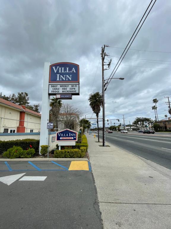 um sinal para uma estalagem de villa ao lado de uma rua em VILLA INN em Anaheim