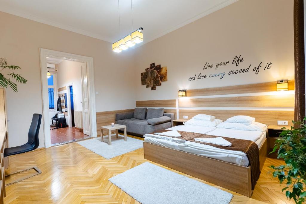 um quarto com uma cama e um sofá em City Center Apartment Debrecen em Debrecen