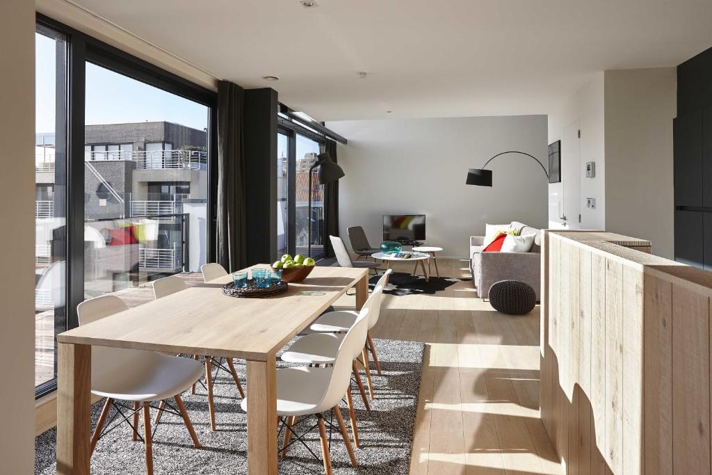 a living room with a wooden table and chairs at Kustappartementen in Blankenberge