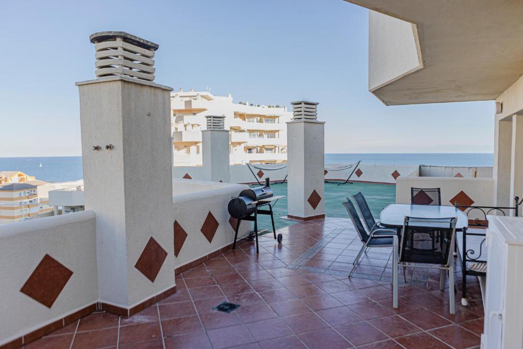 einen Balkon mit einem Tisch, Stühlen und Meerblick in der Unterkunft Benalbeach Penthouse Sea View in Benalmádena