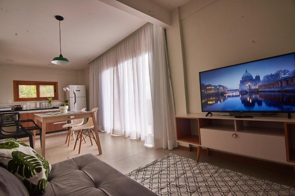 a living room with a large flat screen tv on a wall at Recanto dos Ipês 2 in Domingos Martins