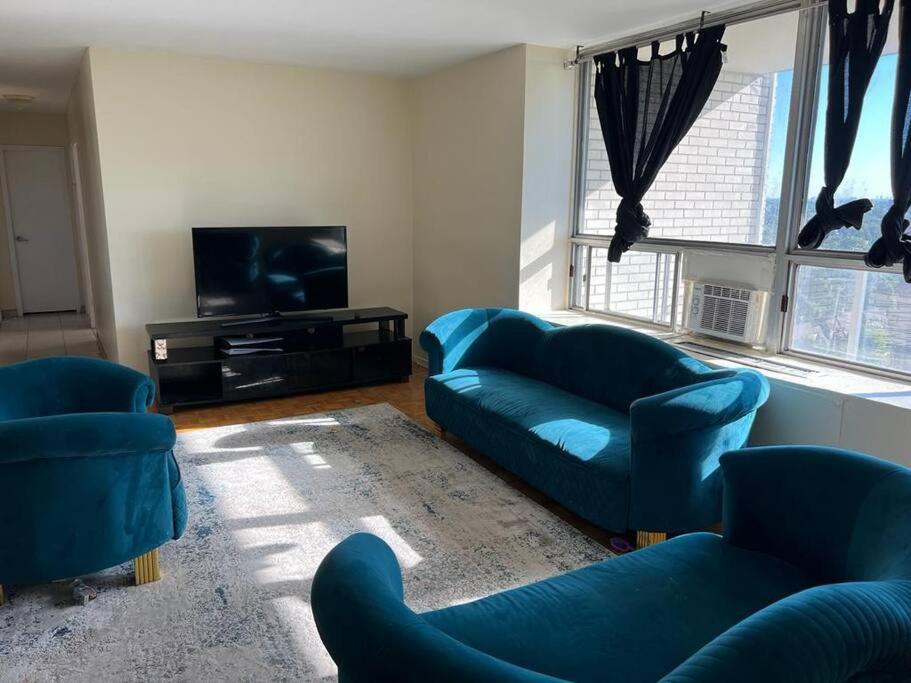 a living room with two blue couches and a tv at Cozy and lovely 2 bed apartment in Toronto