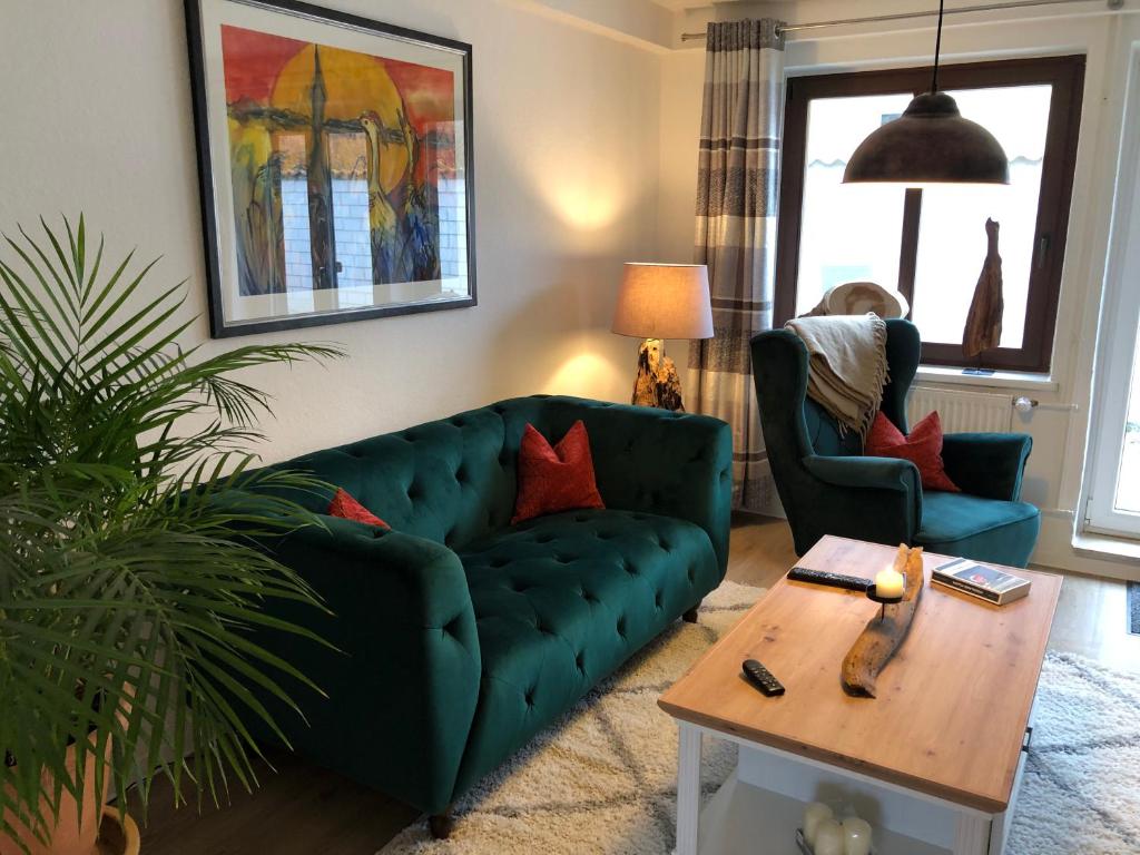 a living room with a green couch and a table at Treibholz in Wustrow