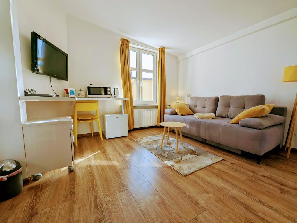 a living room with a couch and a table at Studio Błękitny Wieloryb przy plaży, molo, idealny dla podróżników in Sopot