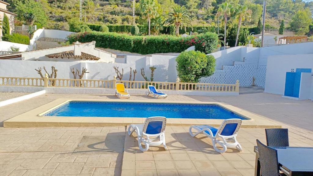 una piscina con sillas y una piscina en Casa Ian, en Moraira