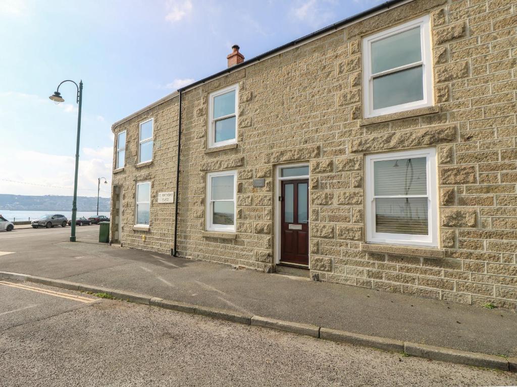 um edifício de tijolos ao lado de uma rua em Jubilee Cottage em Penzance