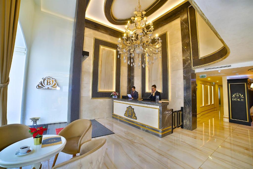 twee mannen aan een balie in een hotellobby bij Büke Hotel in Istanbul