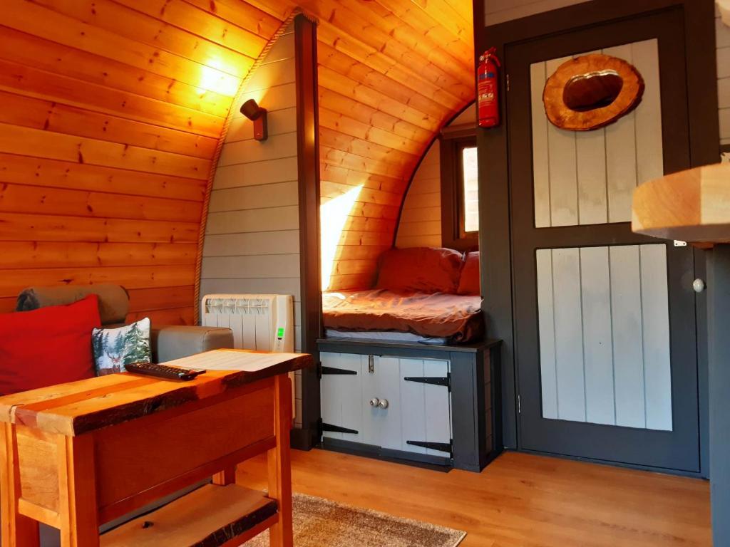 a room with a bed and a desk in a cabin at Coe Pod, West Highland Way Holidays in Kinlochleven