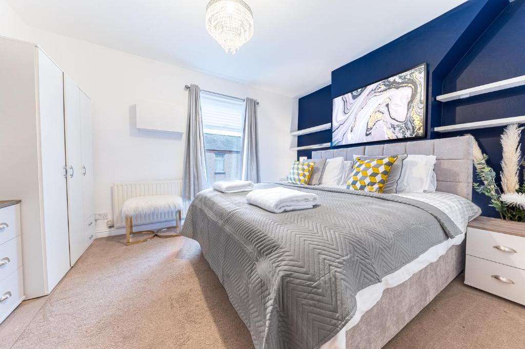 um quarto com uma cama grande e uma parede azul em *King Bed* Comfy City House em Barrow in Furness