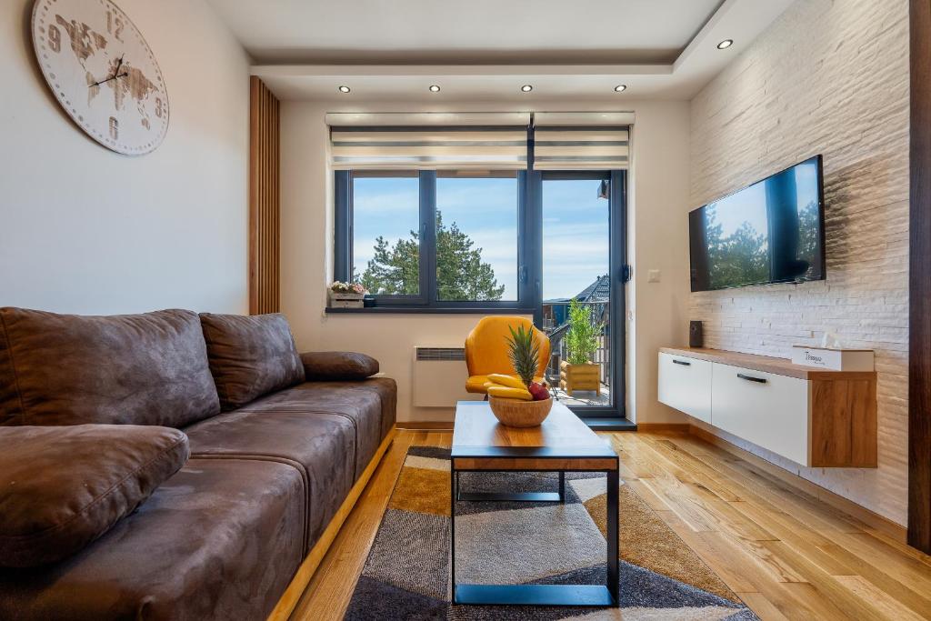 a living room with a couch and a table at Vardar 64 (Titova Vila) in Zlatibor
