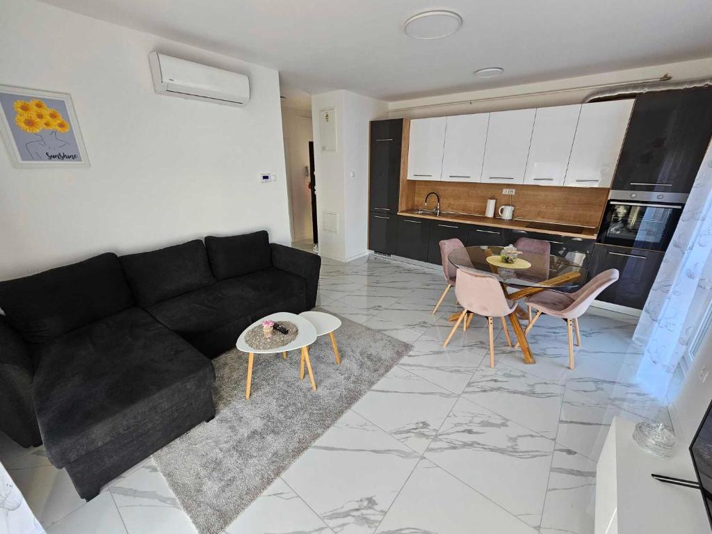 uma sala de estar com um sofá preto e uma mesa em Appartment Podravina em Ðurđevac