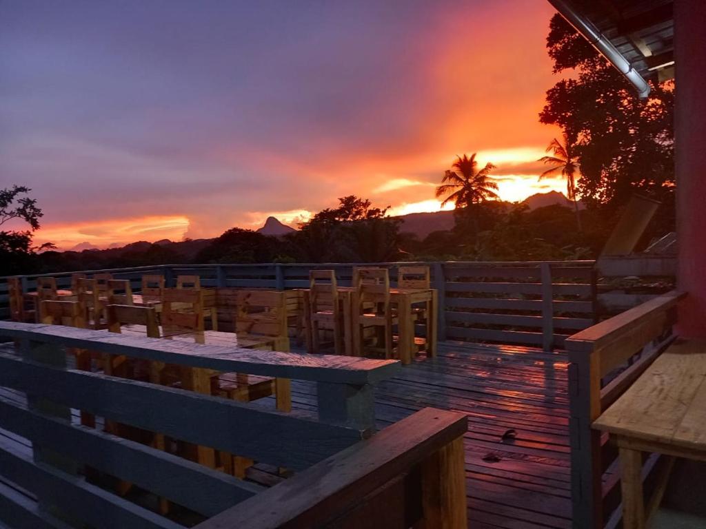 SantʼAnaにあるCasa Cantagalo - Guest House & Bar Restaurantの夕日を望むデッキ(テーブル、椅子付)
