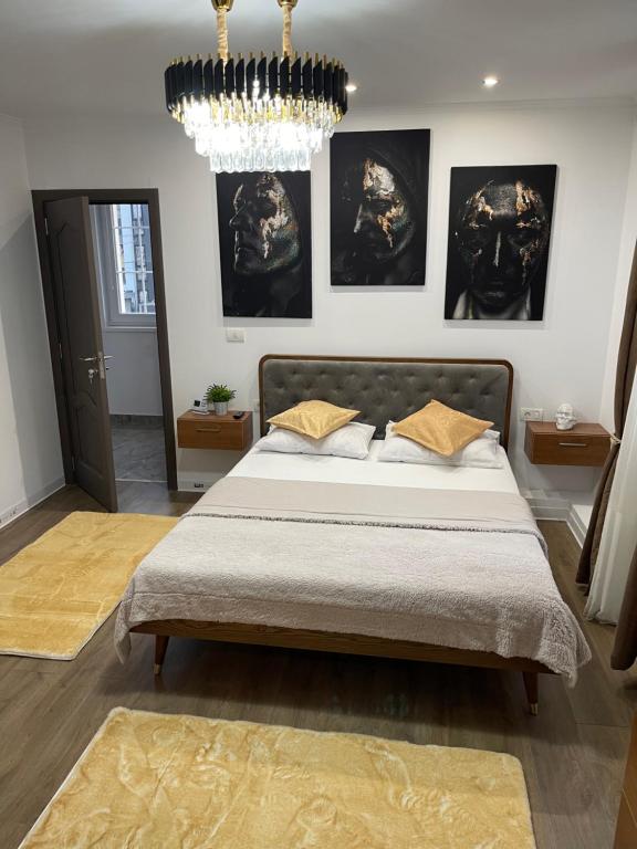 a bedroom with a large bed and a chandelier at Meta Port Apart in Timişoara
