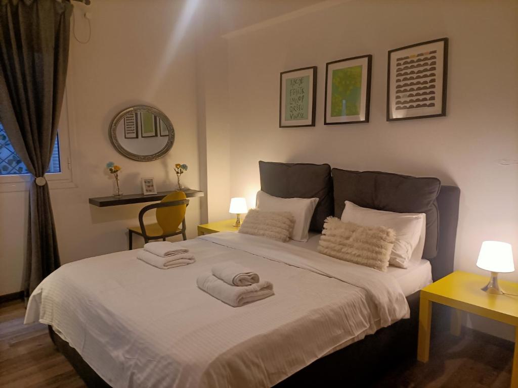 アテネにあるKallimarmaro Cozyのベッドルーム1室(ベッド1台、タオル2枚付)