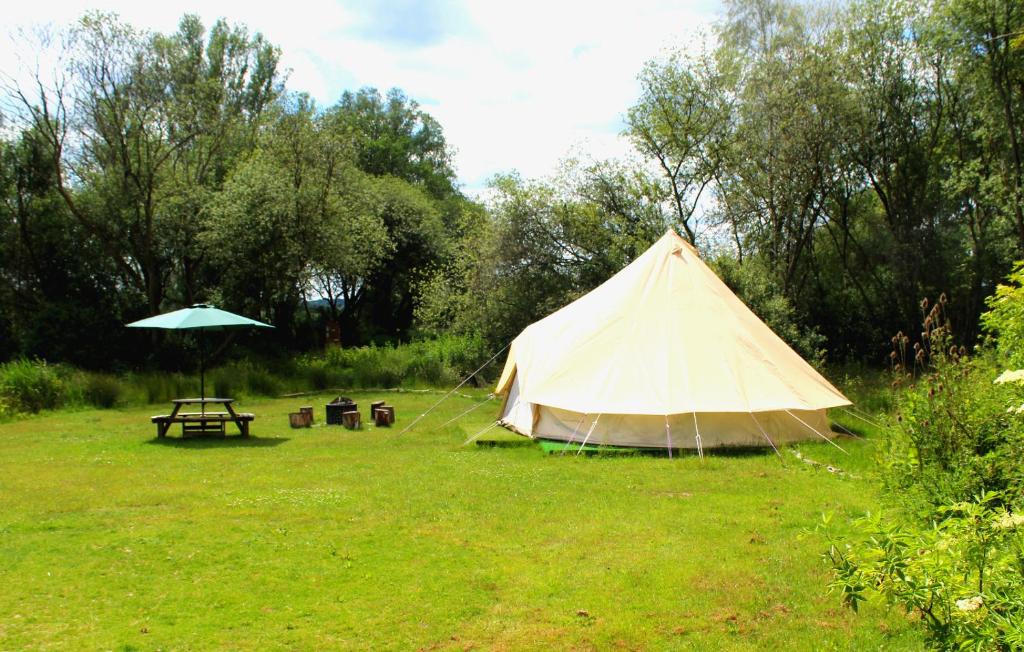 a tent and a picnic table in a field at The Meadows Bell Tents in Clare