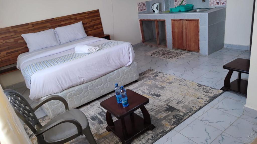 1 dormitorio con 1 cama, mesa y sillas en Marvel Studio Kitengela Yukos, en Kitengela 