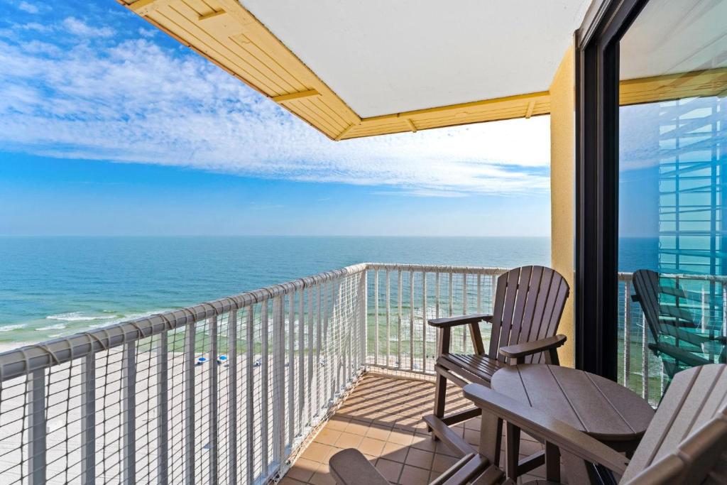 a balcony with chairs and a view of the ocean at Summer House 1501B in Orange Beach
