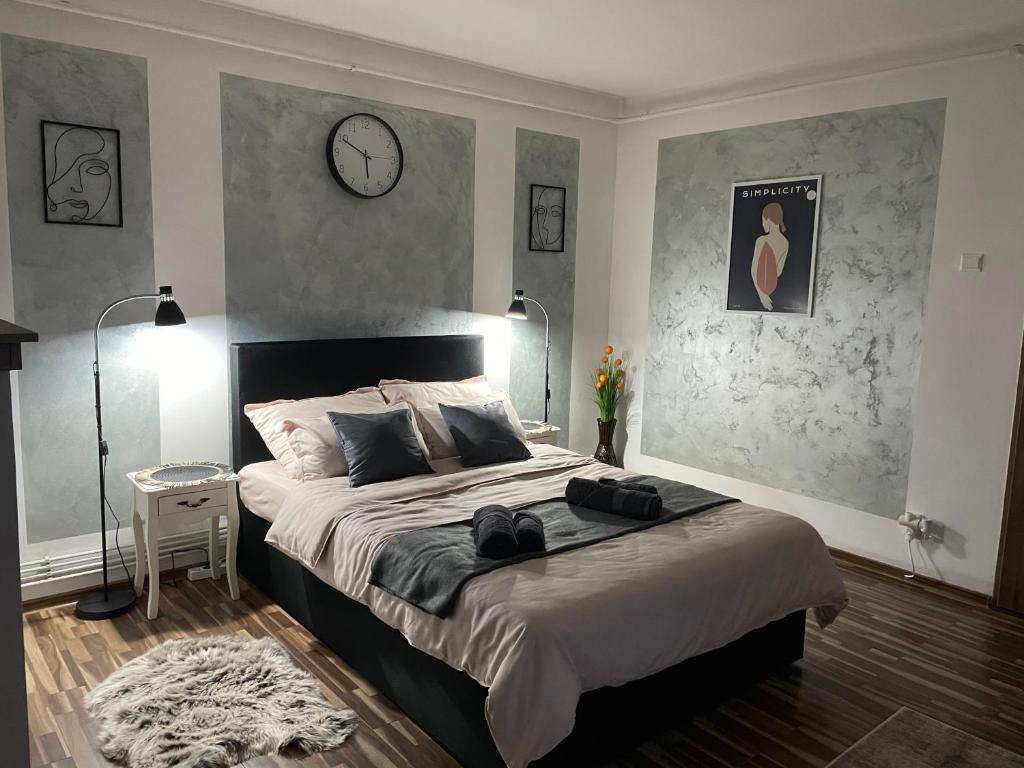una camera con un grande letto e un orologio a muro di luxury central studio a Hunedoara