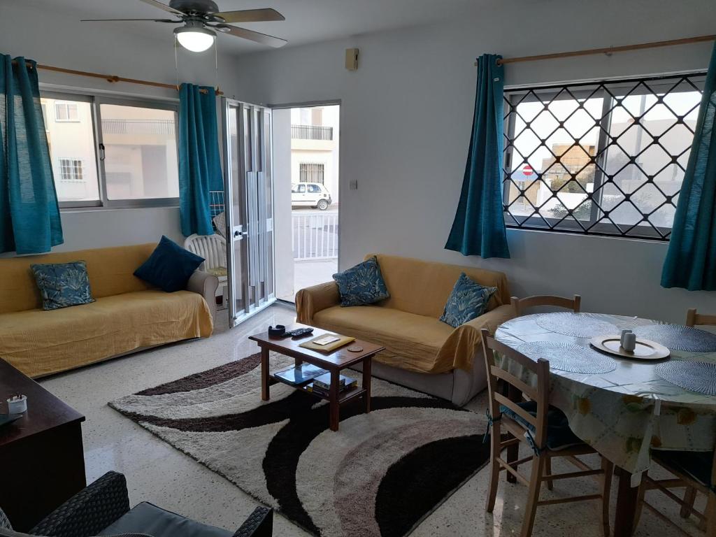 een woonkamer met een bank en een tafel bij Sunshine Holiday Apartment 4 Next to the Sea in St Paul's Bay