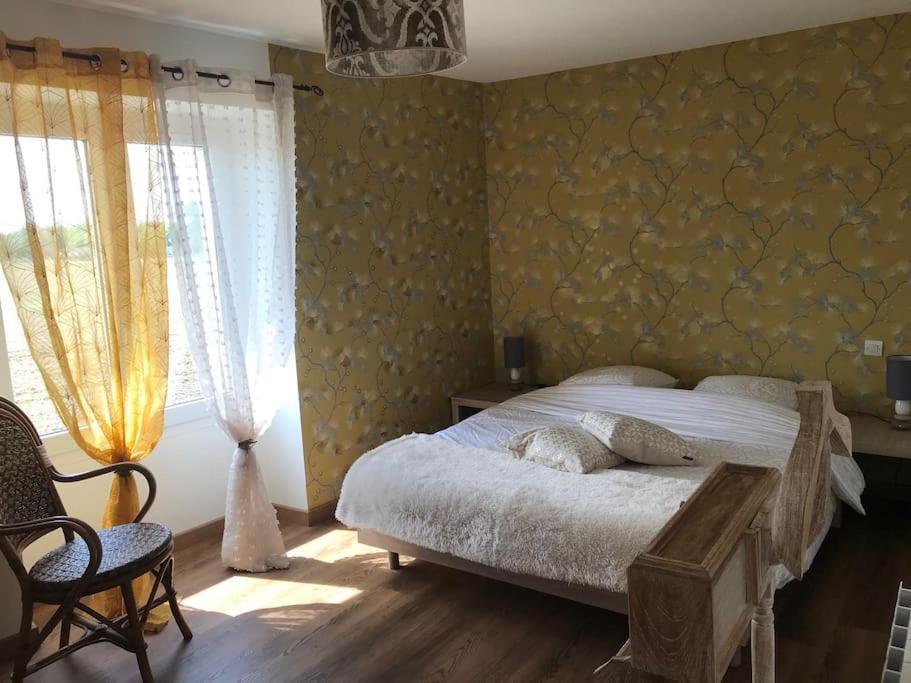 sypialnia z łóżkiem i dużym oknem w obiekcie Gîte Au Petit Bonheur w mieście Saint-Savinien