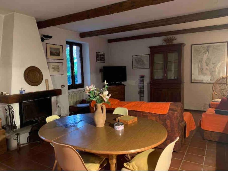 a living room with a table and a couch at Villa Giardino con pontile sul Lago D’Orta in riva in Orta San Giulio