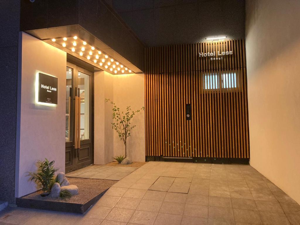 Hotel Less Seoul في سول: مدخل عماره فيها باب مع اناره