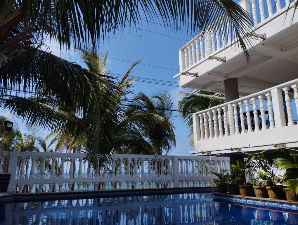 a house with a white fence and a swimming pool at Sunset Paradise in San Andrés