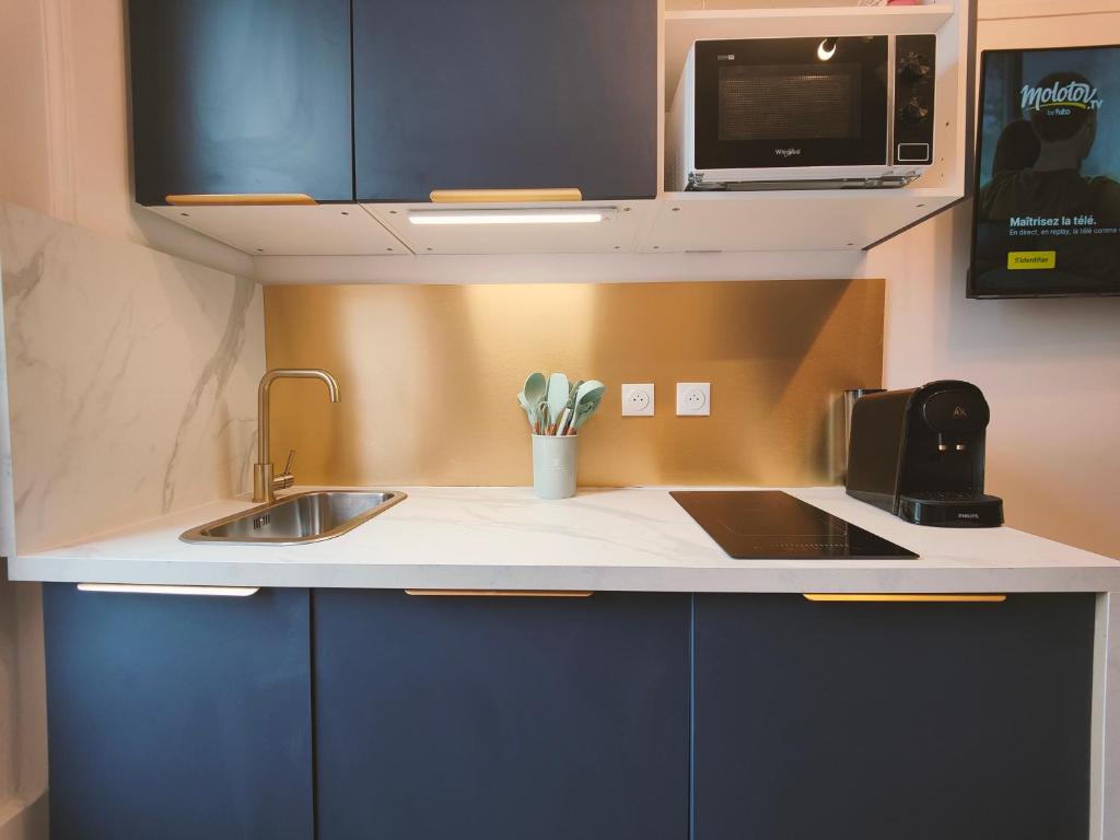 a kitchen with a sink and a microwave at Le Chic in Ivry-sur-Seine