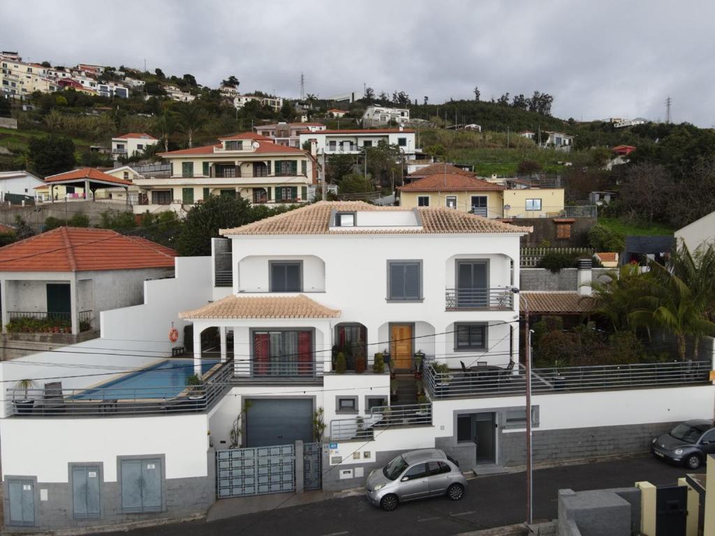 uma casa branca com um carro estacionado em frente dela em Sea and Sun 4 You - Choupana Studio no Funchal