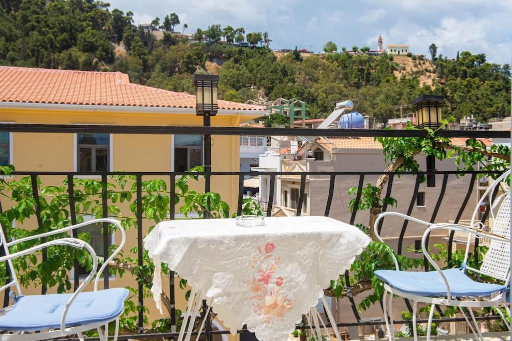 una mesa y sillas en un balcón con vistas en Attic flat ''Tsoukalas Group'', en Zakynthos