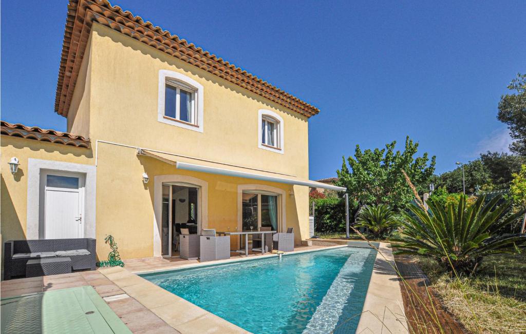 a villa with a swimming pool in front of a house at Awesome Home In Saint Raphael With 3 Bedrooms, Outdoor Swimming Pool And Heated Swimming Pool in Saint-Raphaël