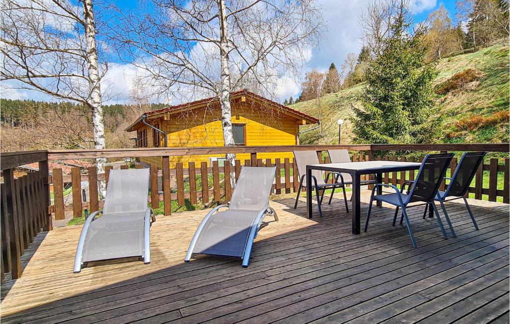 a wooden deck with a table and chairs on it at Nice Home In Masserberg Ot Fehrenba With Wifi And 2 Bedrooms in Fehrenbach