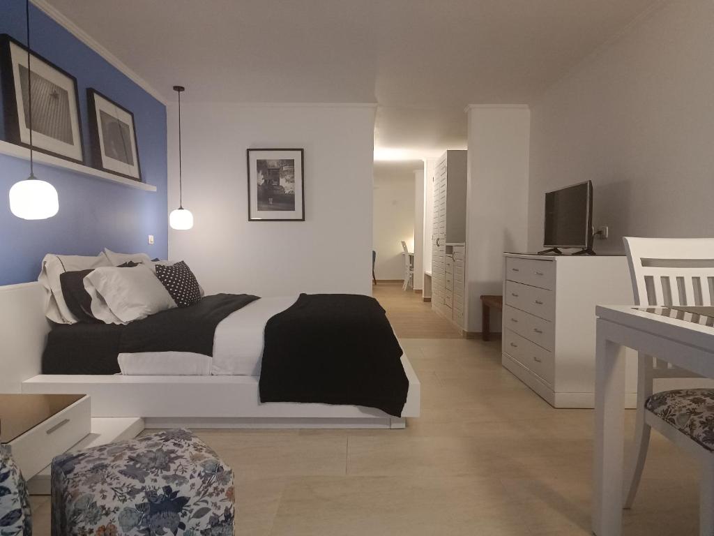 um quarto com uma cama branca e uma televisão em Hotel Boutique Confort Suites em Popayán