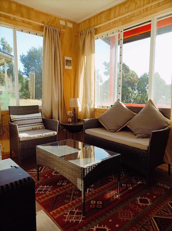 a living room with a couch and a coffee table at Cabañas Aulen Chepu Chiloe in Ancud