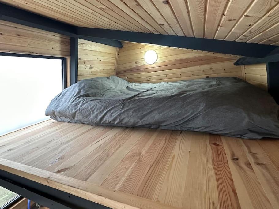 a bed in a wooden cabin with a wooden floor at 5- Modern tasarım ahşap ev in Çatalca
