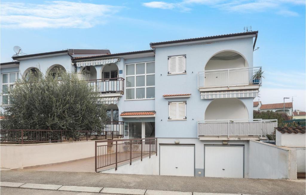 a white building with balconies and a tree at Stunning Apartment In Vabriga With Wifi in Vabriga