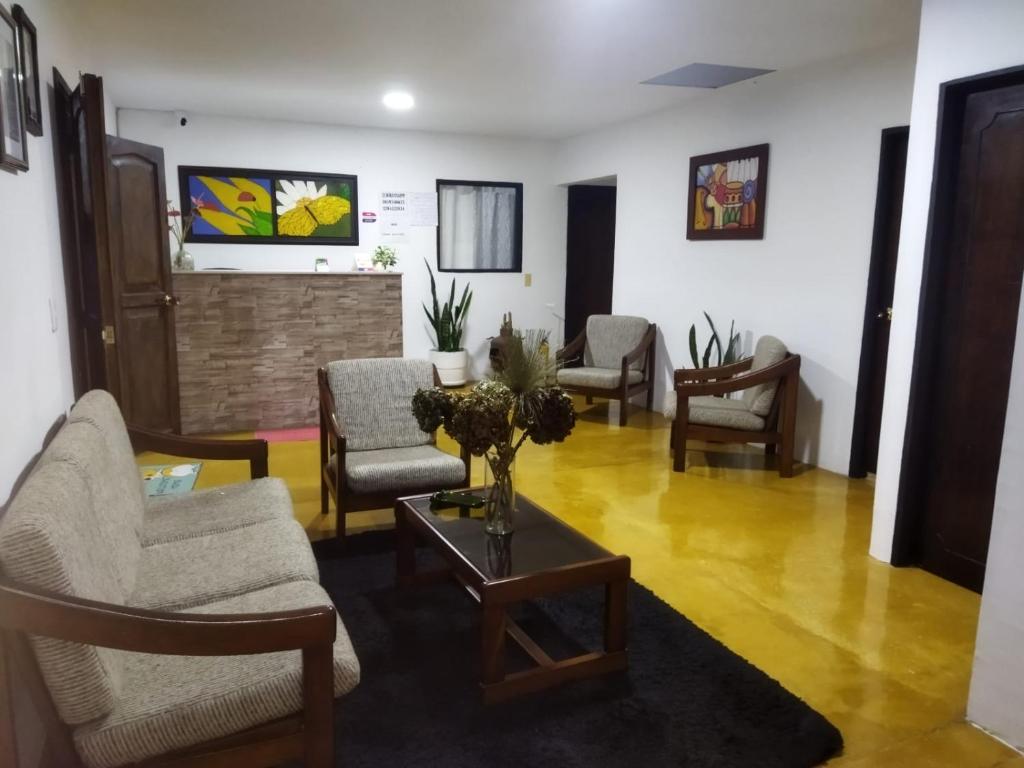 sala de estar con sillas, sofá y mesa en Hostal Villa del Sol, en Salento