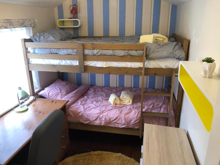 a dorm room with two bunk beds and a desk at Charming 2 bedroom flat in Canterbury