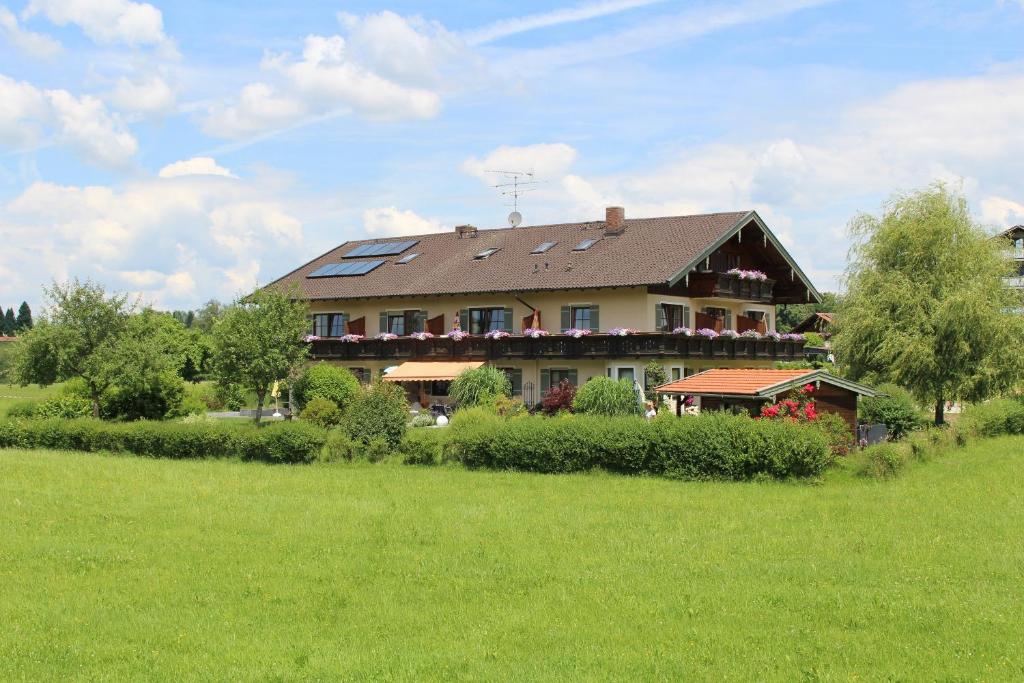 a large house with solar panels on top of a field at Kurparkpension Stephan in Bad Endorf