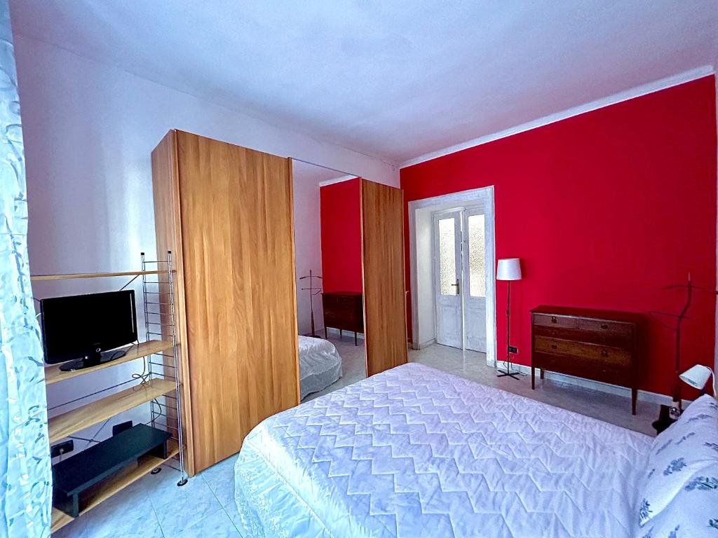 1 dormitorio con cama y pared roja en Bella House, a 200 metri dalla metropolitana, en Turín