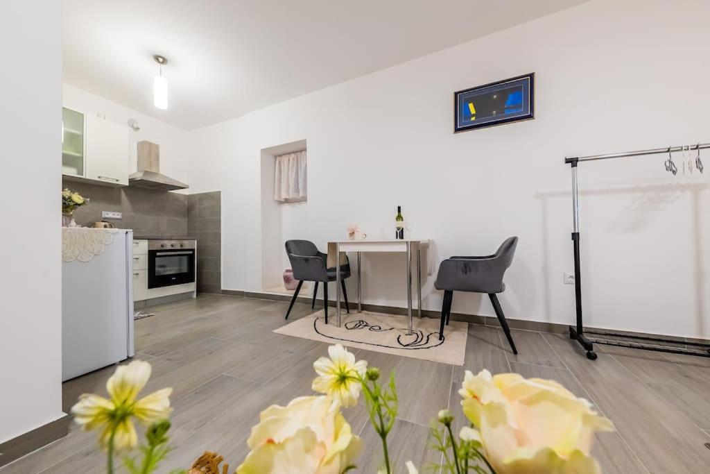a living room with a table and chairs in it at Bozena's studio apartment in Split