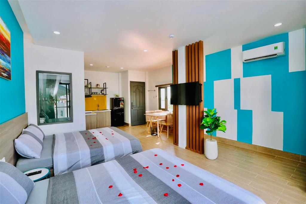 a hotel room with two beds and a kitchen at HÀO PHÁT HOTEL NHA TRANG in Nha Trang