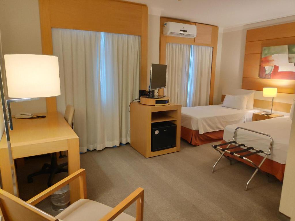 une chambre d'hôtel avec un lit et une télévision dans l'établissement Aconchegante Maravilhoso Flat Congonhas 1416, à São Paulo