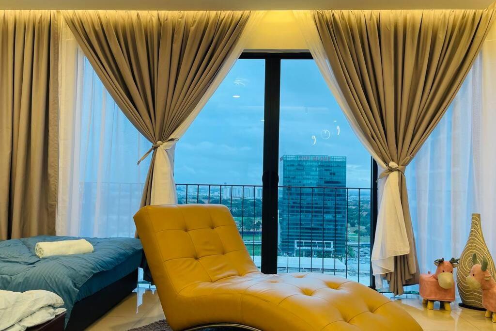 a bedroom with a yellow chair and a large window at D'puncak Trefoil Setia Alam in Setia Alam