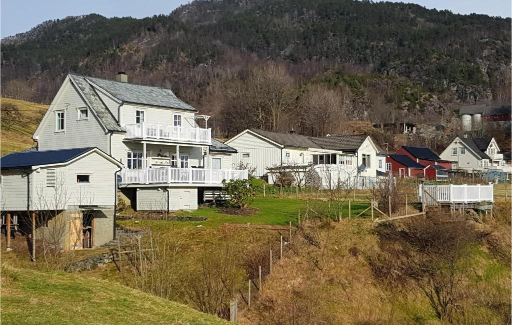 a group of houses on a hill next to a mountain at Lovely Home In Utker With Wifi in Utåker