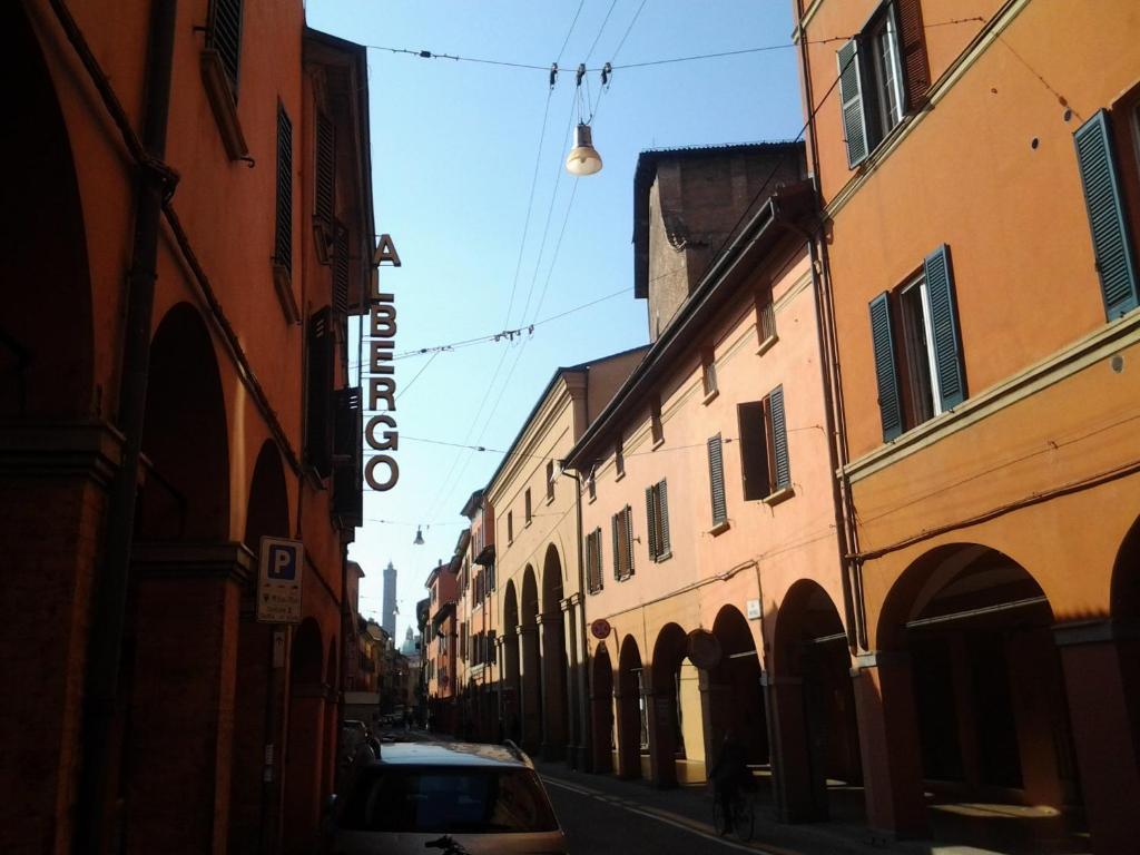 ein Auto, das auf einer Straße zwischen zwei Gebäuden parkt in der Unterkunft Hotel Perla in Bologna