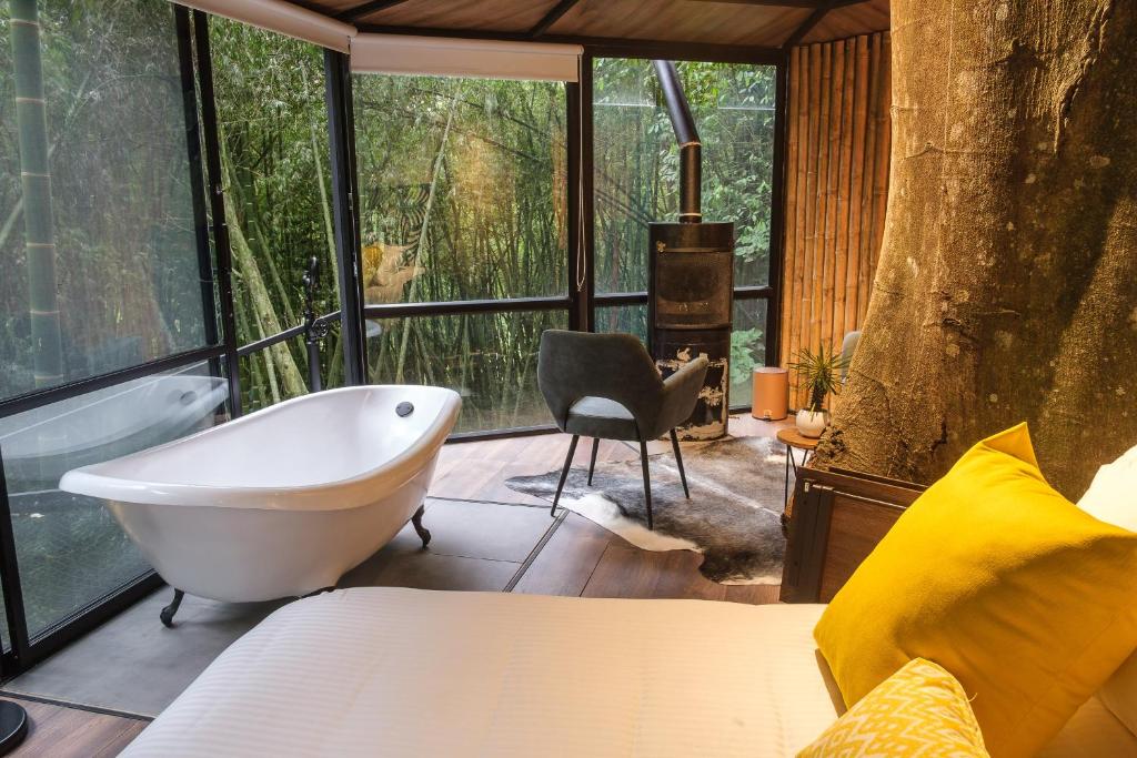 a bedroom with a bath tub in a tree house at Amanatu Ecolodge & Spa in Quimbaya