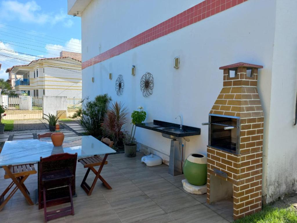 a patio with a brick oven and a table at Maria Farinha casa in Maria Farinha