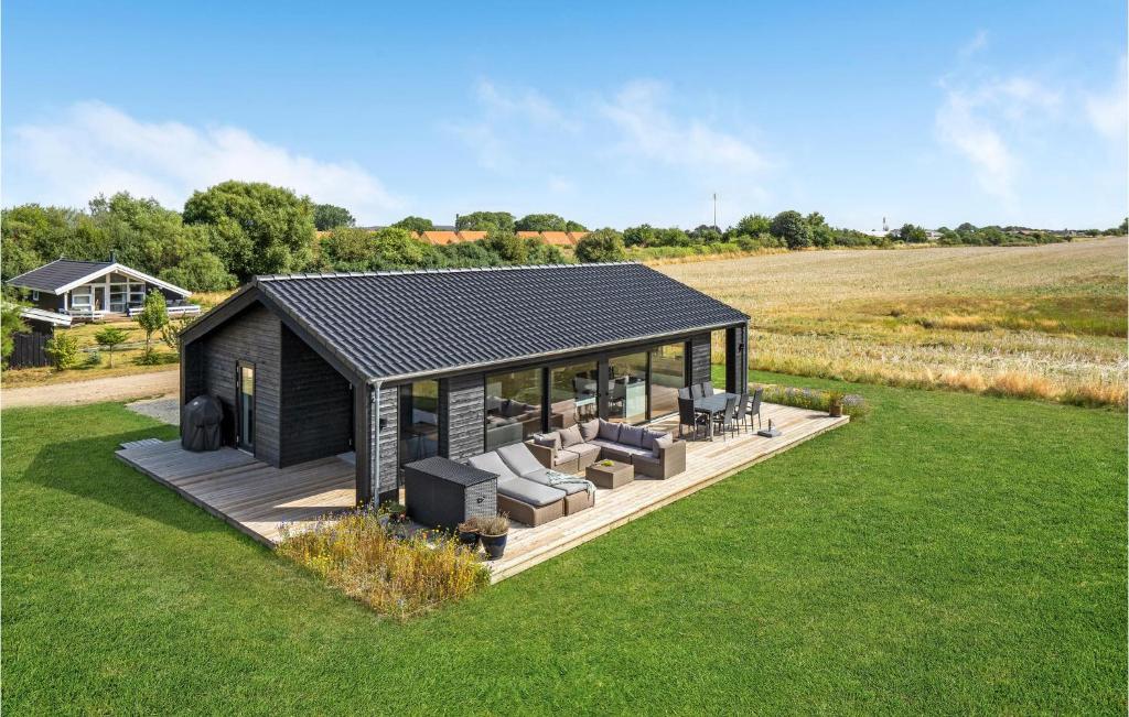 una casa con techo negro en un campo de césped en Beautiful Home In Fllenslev With Wifi, en Føllenslev